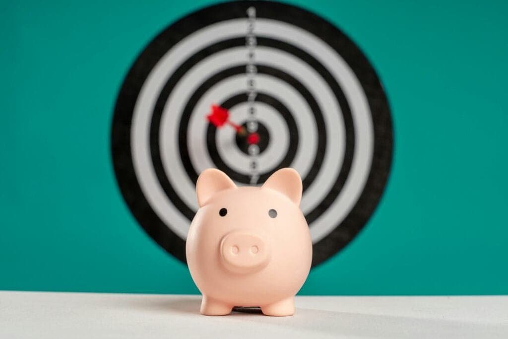 Piggy bank in front of a red bullseye symbolizing smart nonprofit spending through mobile billboard advertising
