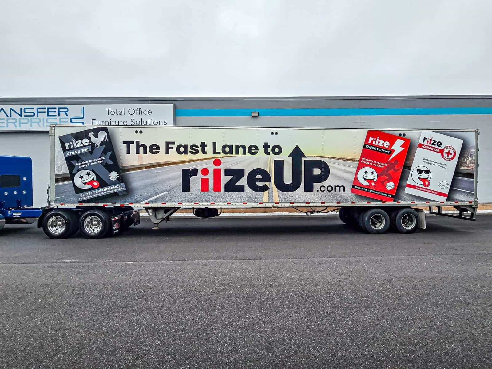 Close-up side view of a mobile billboard trailer displaying a large-format branded advertisement.