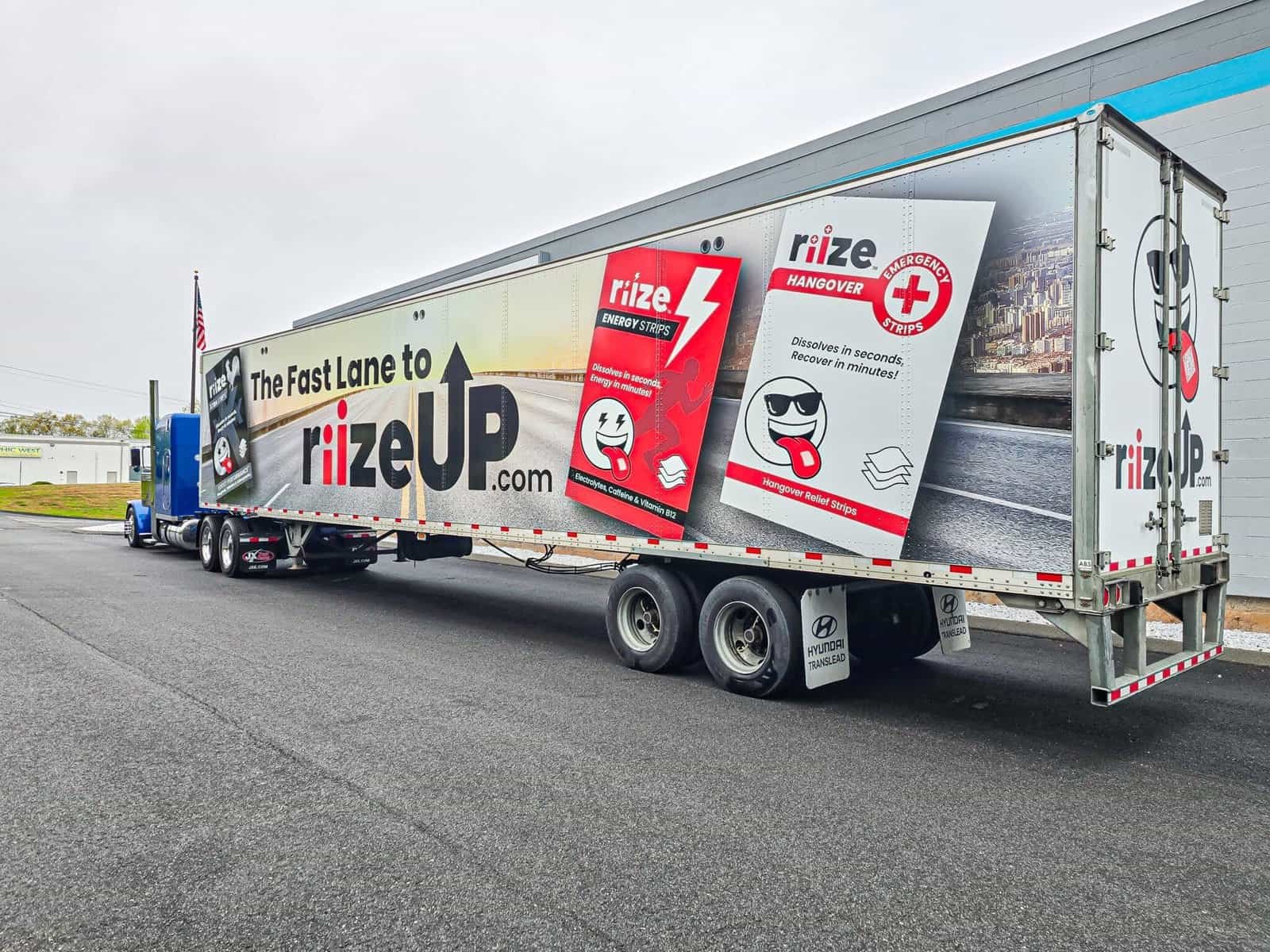 Highway truck trailer advertising Rize Up energy strips with bold graphics and product images for roadside visibility.